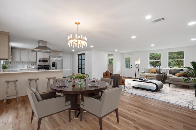 dining space featuring an inviting chandelier and light hardwood / wood-style floors