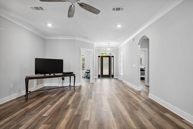 living room with dark wood-type flooring, ceiling fan, and crown molding