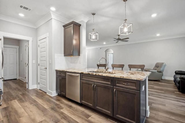 kitchen featuring decorative light fixtures, stainless steel dishwasher, dark brown cabinetry, and sink