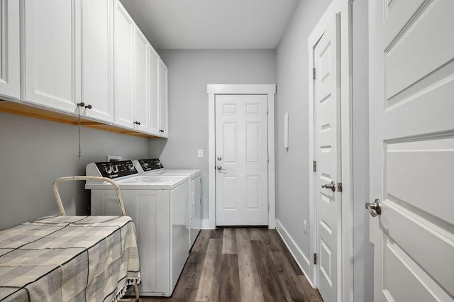 washroom featuring dark hardwood / wood-style flooring, washer and clothes dryer, and cabinets