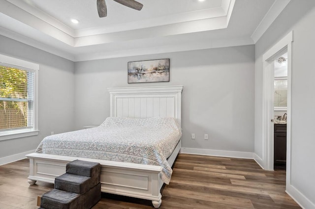 bedroom with ceiling fan, a raised ceiling, and dark hardwood / wood-style floors