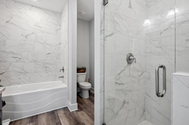 bathroom featuring toilet, hardwood / wood-style floors, and plus walk in shower