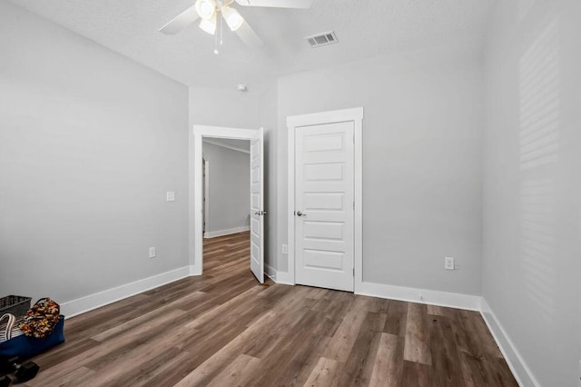 unfurnished bedroom featuring ceiling fan and dark hardwood / wood-style floors