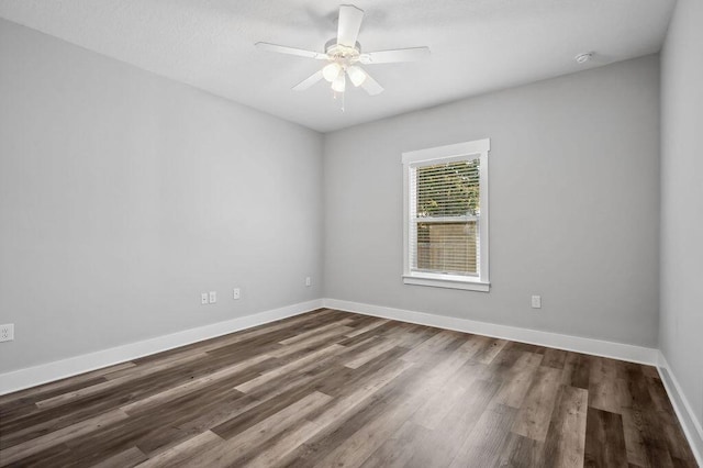 spare room with dark hardwood / wood-style flooring and ceiling fan