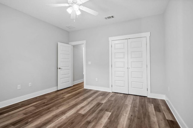 unfurnished bedroom with wood-type flooring, ceiling fan, and a closet