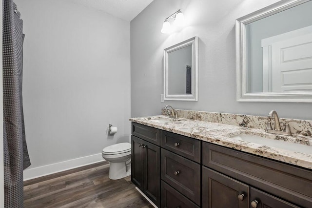 bathroom with toilet, wood-type flooring, and vanity