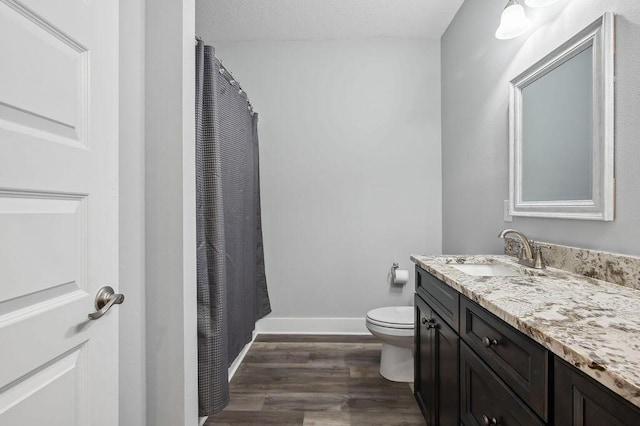 bathroom with toilet, hardwood / wood-style flooring, a textured ceiling, and vanity