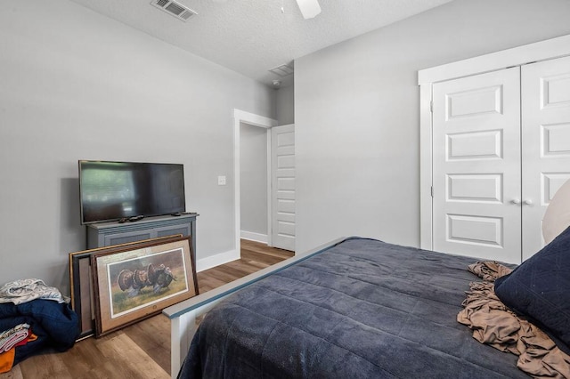 bedroom featuring ceiling fan, a closet, and dark hardwood / wood-style flooring