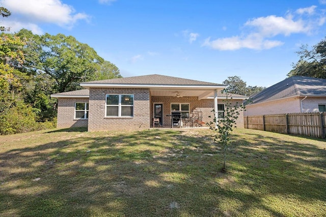 rear view of property featuring a patio and a lawn