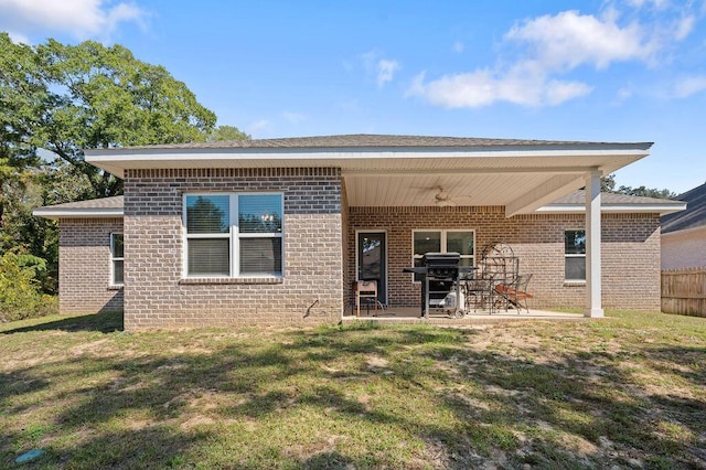 rear view of house with a patio and a yard