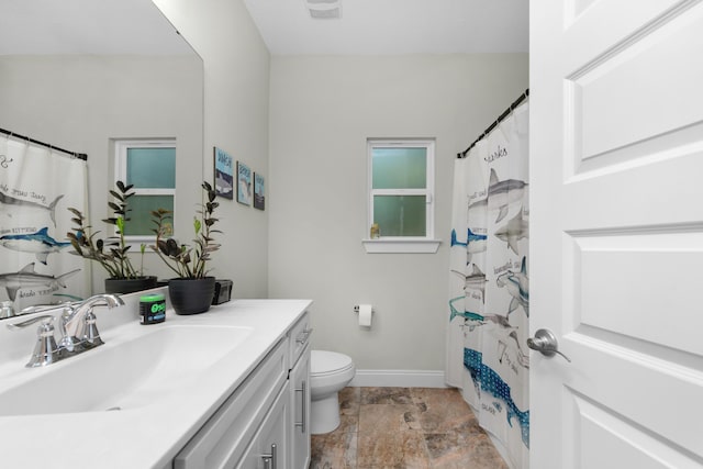 bathroom featuring walk in shower, vanity, and toilet