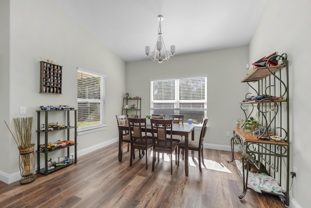 dining space with dark hardwood / wood-style flooring and a chandelier