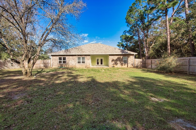 rear view of property with a lawn