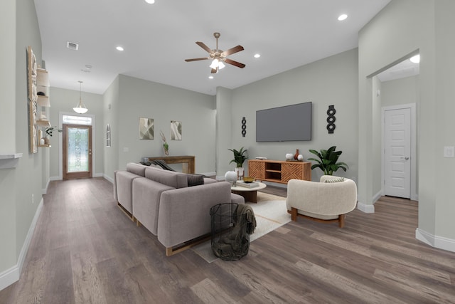 living room featuring recessed lighting, visible vents, baseboards, and wood finished floors