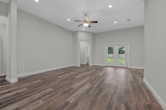 unfurnished living room with recessed lighting, baseboards, dark wood finished floors, and french doors