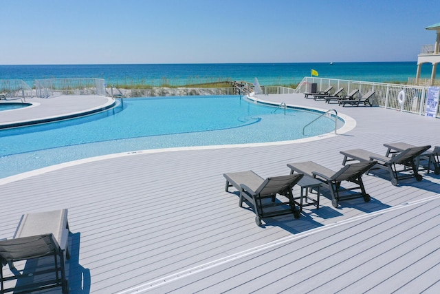 view of swimming pool featuring a water view and a patio area