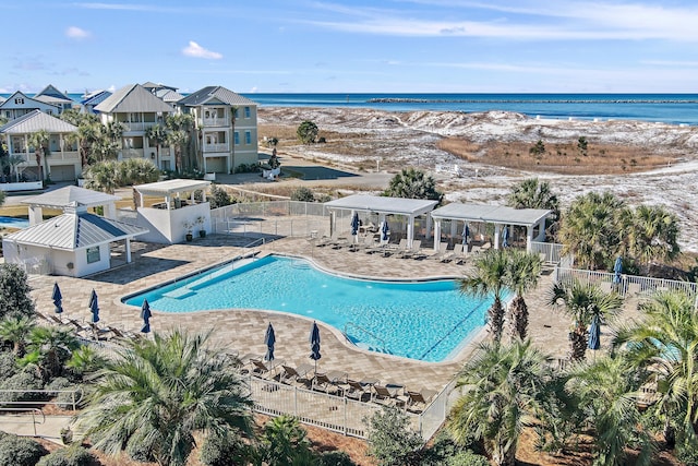 view of swimming pool with a patio, a beach view, a gazebo, and a water view