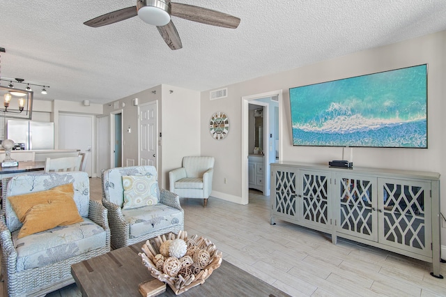 living room featuring a textured ceiling and ceiling fan