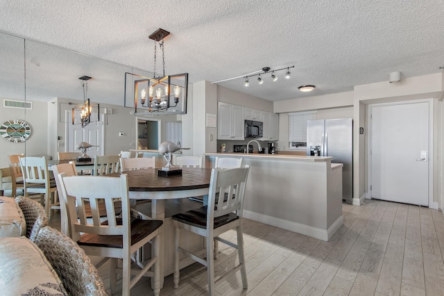 dining space featuring a notable chandelier and light hardwood / wood-style floors