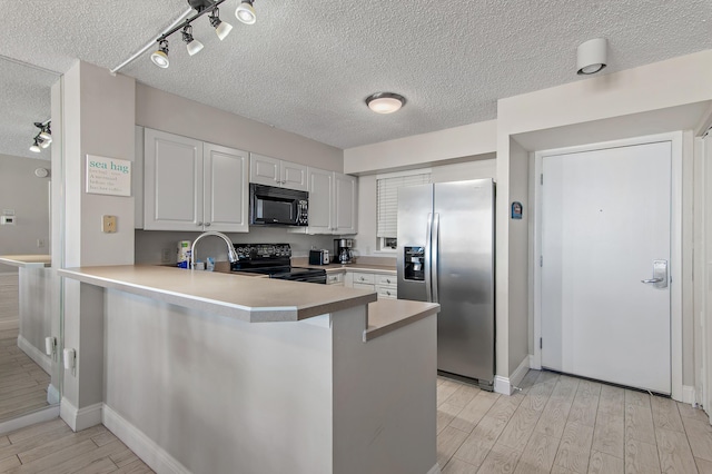 kitchen featuring black appliances, white cabinets, sink, and kitchen peninsula