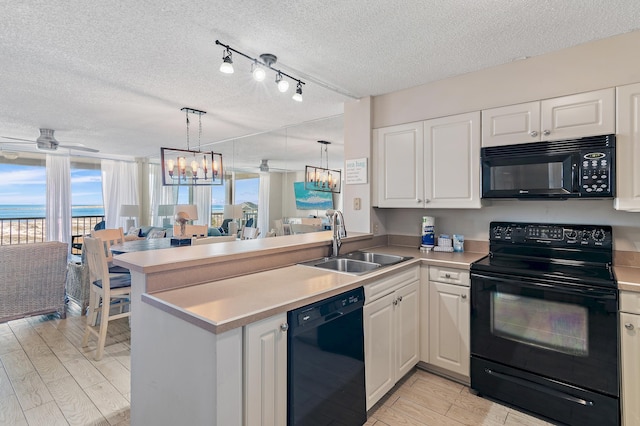 kitchen with sink, white cabinets, black appliances, and kitchen peninsula