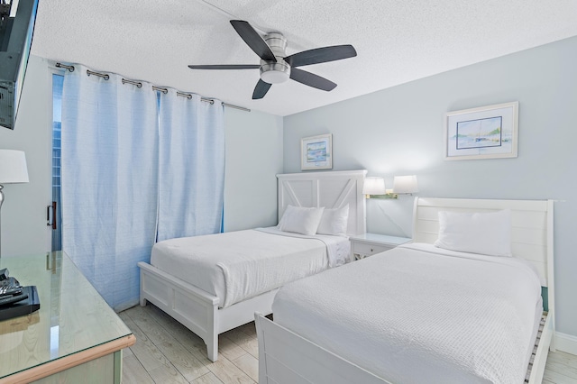 bedroom with ceiling fan and a textured ceiling