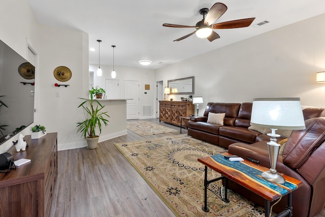 living room with ceiling fan and light hardwood / wood-style flooring