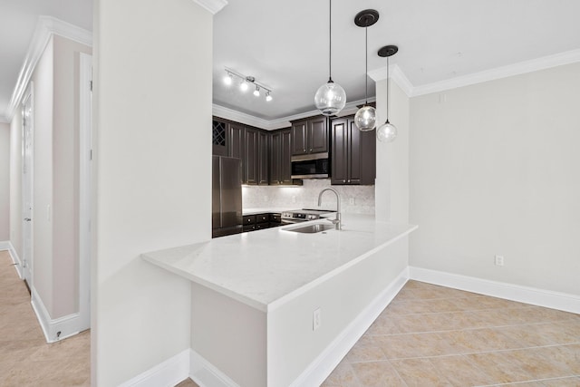 kitchen with decorative light fixtures, sink, crown molding, stainless steel appliances, and dark brown cabinets