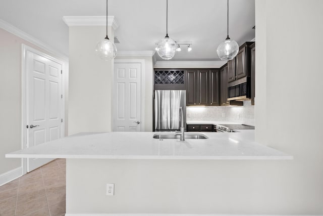 kitchen featuring decorative light fixtures, dark brown cabinetry, appliances with stainless steel finishes, and kitchen peninsula