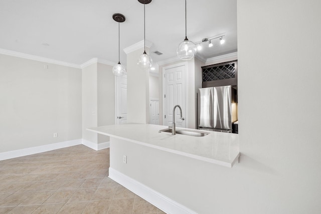 kitchen featuring pendant lighting, stainless steel refrigerator, sink, ornamental molding, and kitchen peninsula