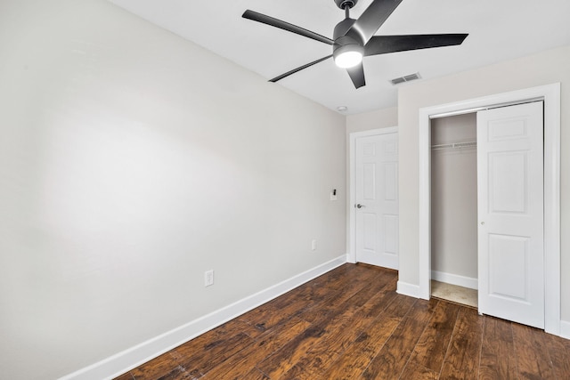 unfurnished bedroom with dark wood-type flooring, ceiling fan, and a closet