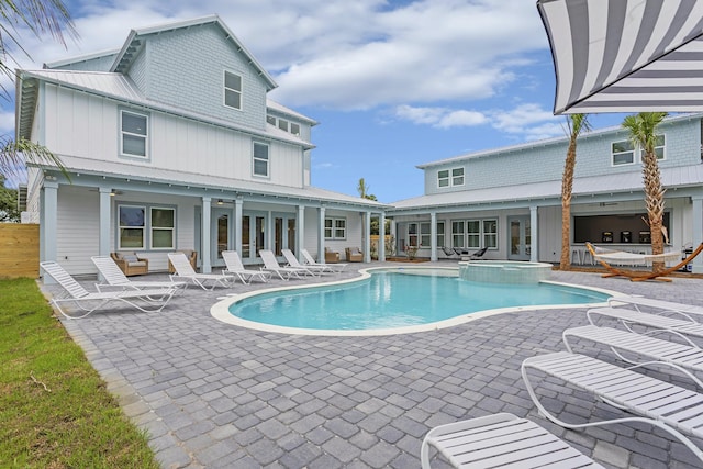 view of pool featuring a patio and an in ground hot tub