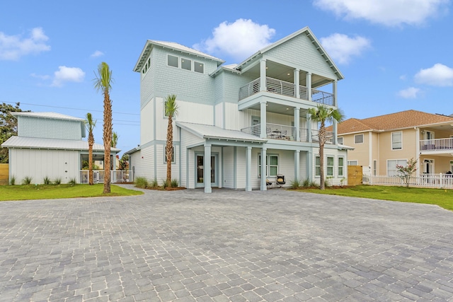 view of front of property featuring a balcony and a front lawn