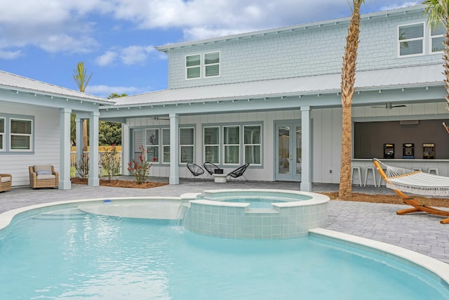 view of pool featuring french doors, a patio area, ceiling fan, and an in ground hot tub