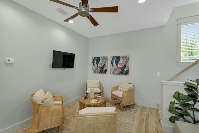 sitting room with vaulted ceiling, light wood-type flooring, and ceiling fan