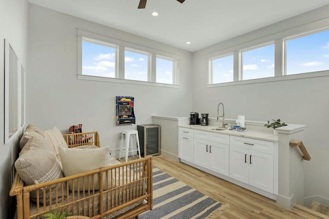 interior space with light wood-type flooring, ceiling fan, and sink