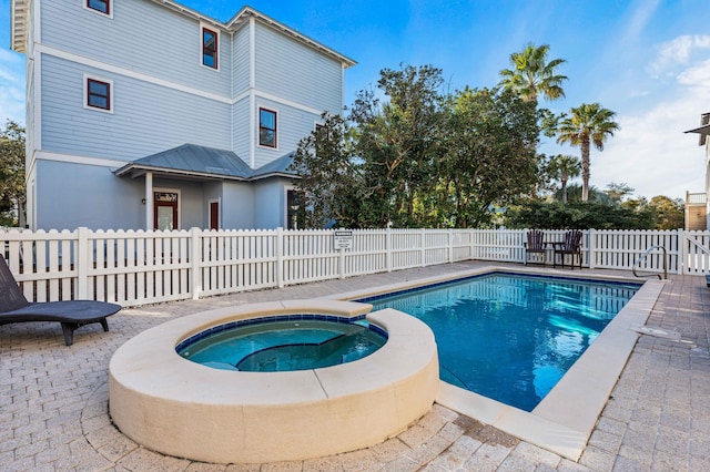 view of swimming pool featuring an in ground hot tub and a patio