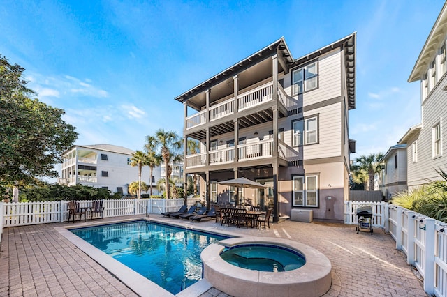 view of pool featuring an in ground hot tub and a patio