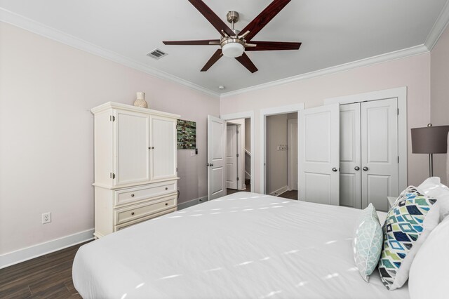 bedroom with dark wood-type flooring, ceiling fan, ornamental molding, and a closet