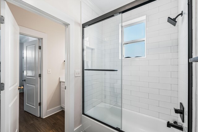 bathroom featuring vanity, hardwood / wood-style floors, and enclosed tub / shower combo