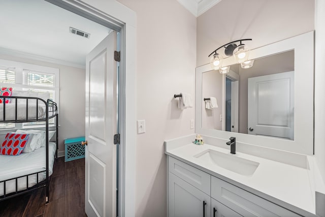 bathroom featuring vanity, hardwood / wood-style flooring, and ornamental molding