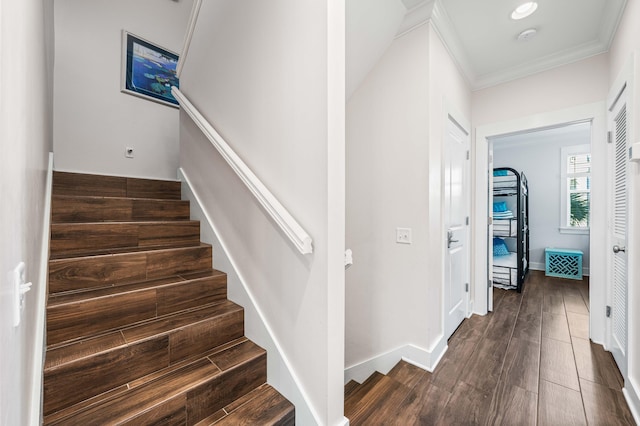 staircase featuring wood-type flooring and ornamental molding