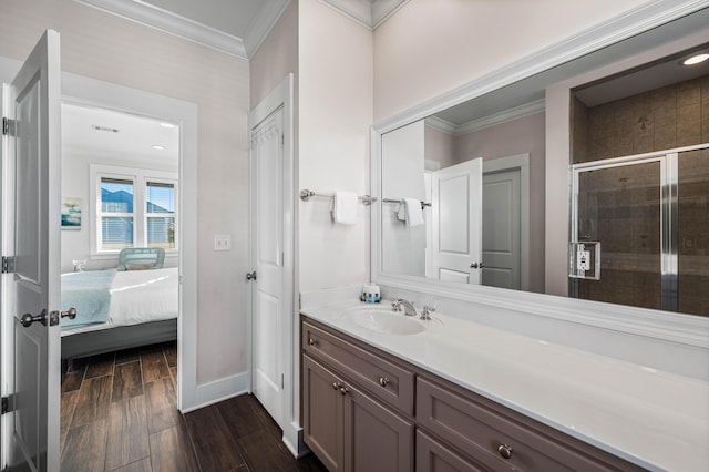 bathroom featuring an enclosed shower, vanity, crown molding, and wood-type flooring