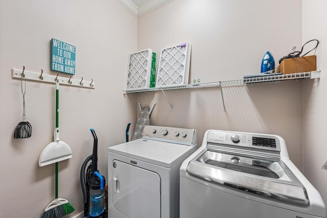 laundry room featuring ornamental molding and washer and dryer