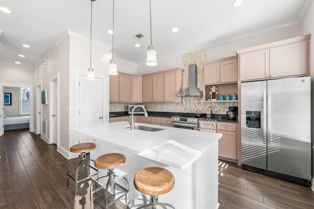 kitchen featuring stainless steel appliances, sink, light brown cabinetry, and wall chimney exhaust hood