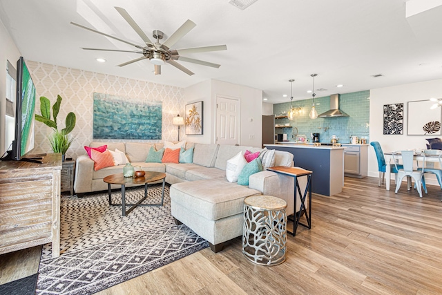 living room with light wood-type flooring and ceiling fan