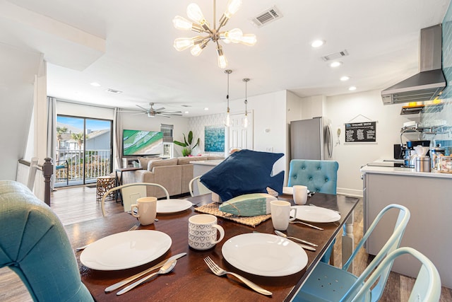 dining area with light hardwood / wood-style floors and ceiling fan with notable chandelier