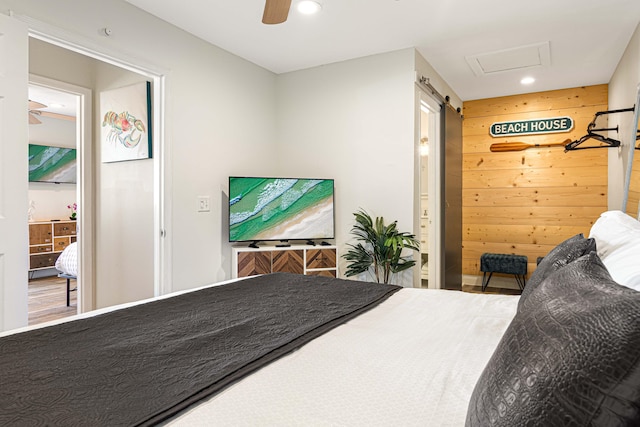 bedroom featuring ceiling fan and wood walls