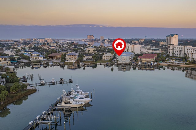 aerial view at dusk featuring a water view