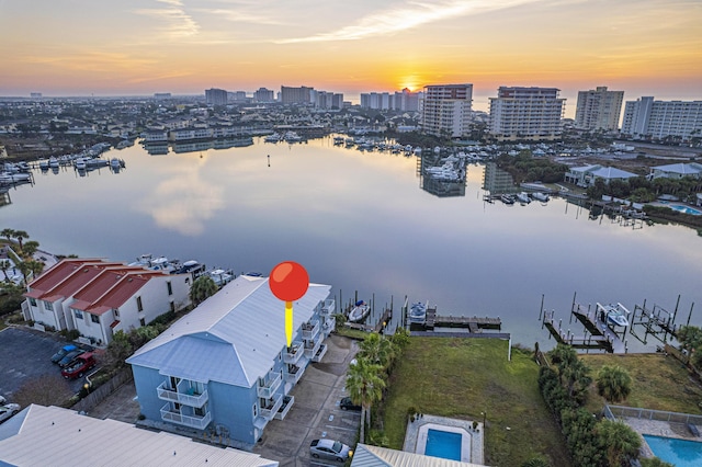 aerial view at dusk featuring a water view